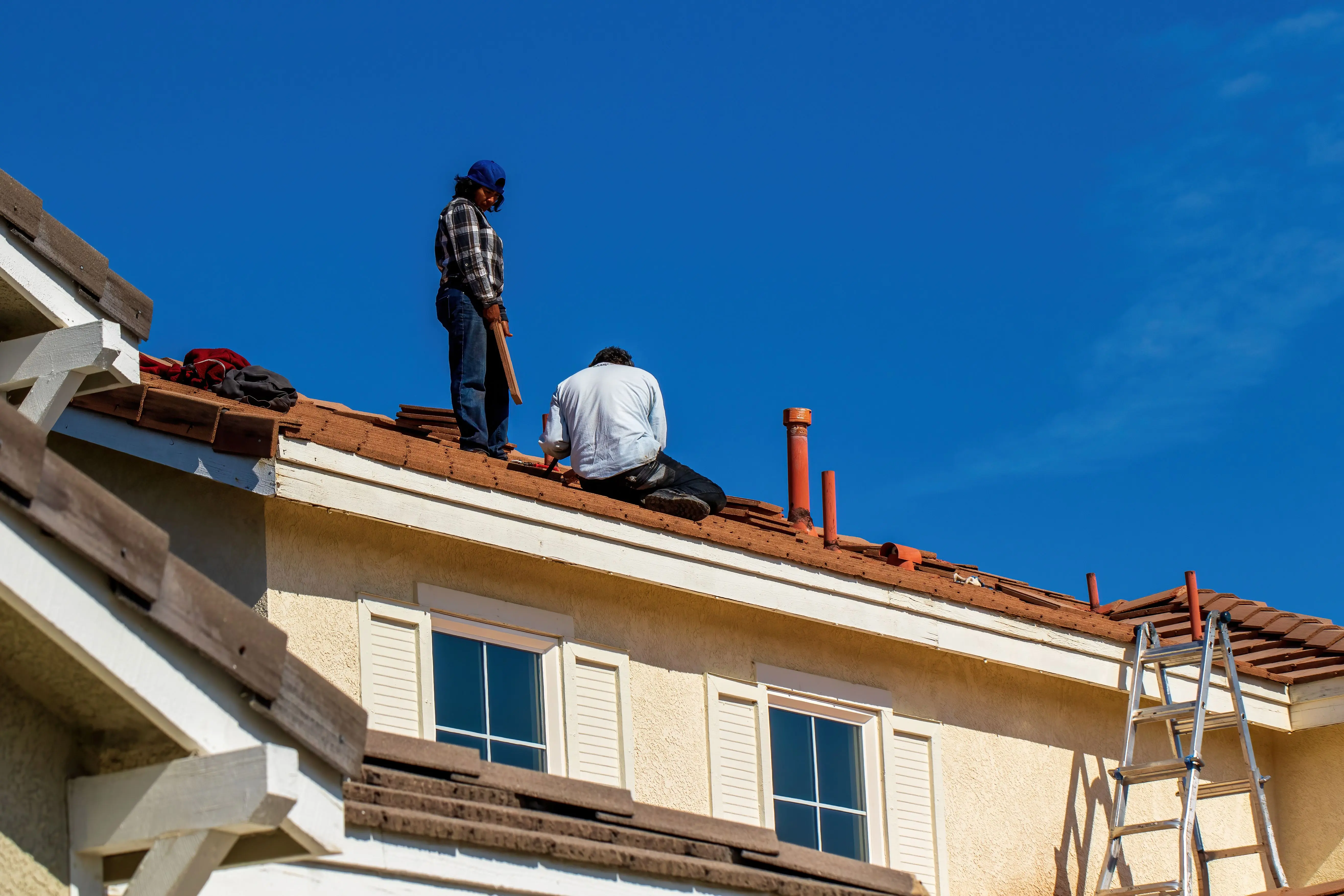 Équipe de couvreurs posant des tuiles lors d'une rénovation de toiture